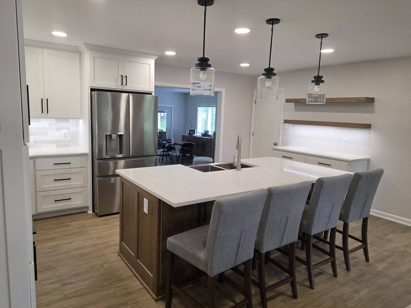 The same white and oak kitchen from the other end, with floating oak shelves